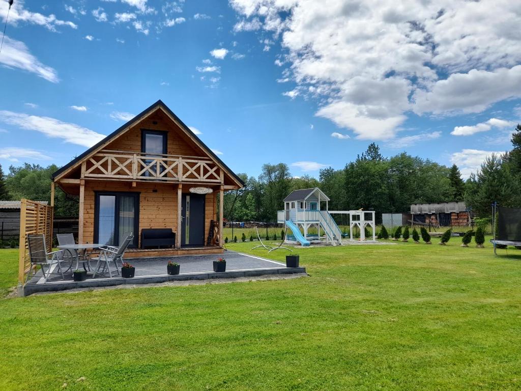 a small cabin in a field with a playground at Orawski Kąt in Zubrzyca Dolna