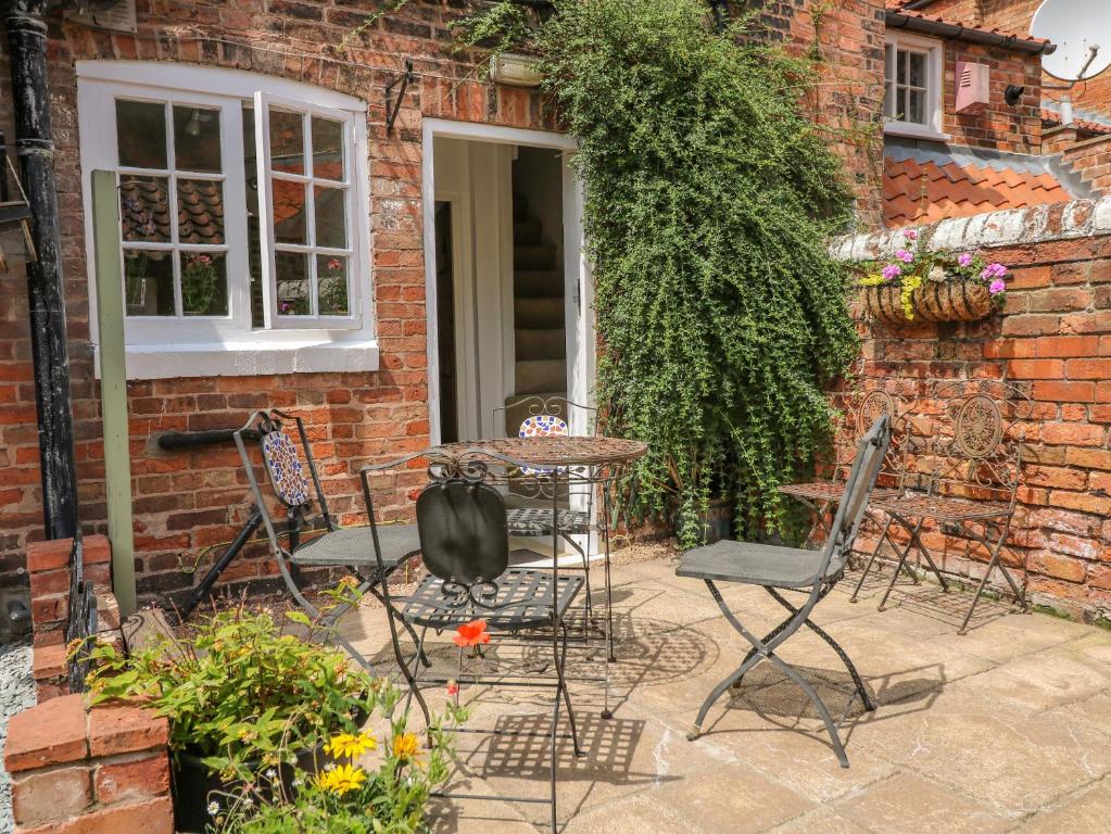 a patio with chairs and a table in front of a building at The Old Sweet Shop in Newark-on-Trent