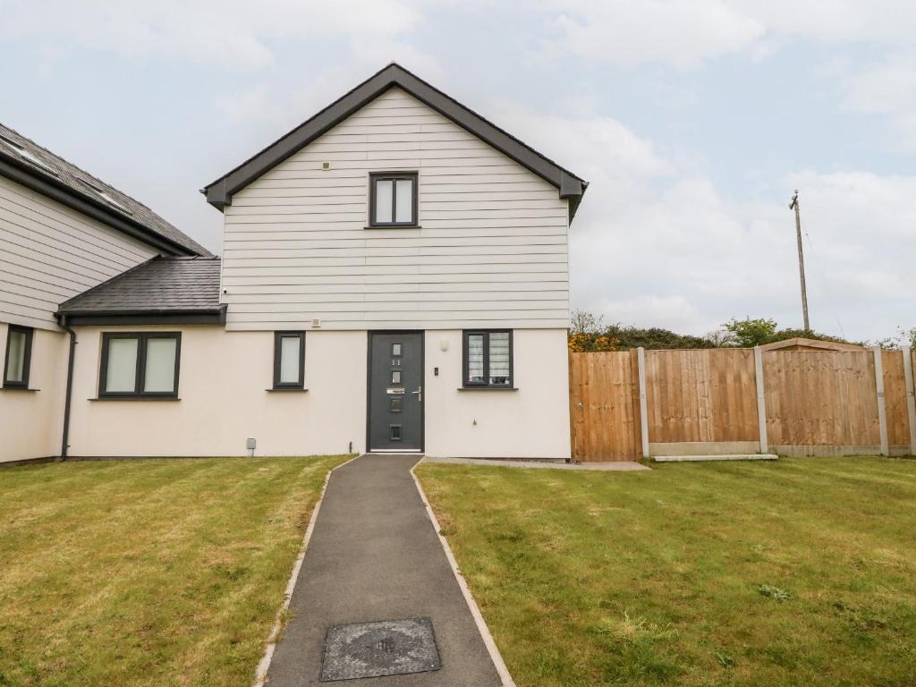 a white house with a yard at 11 Parc Delfryn in Brynteg