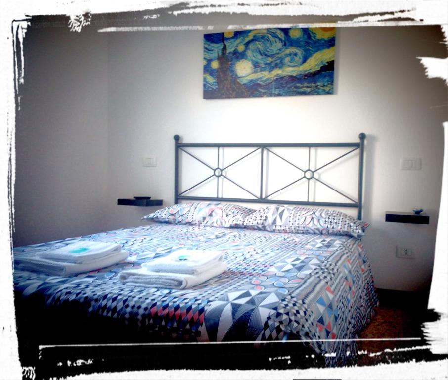 a bedroom with a bed with a blue and white comforter at L'Altra Modica Locazione Turistica in Modica