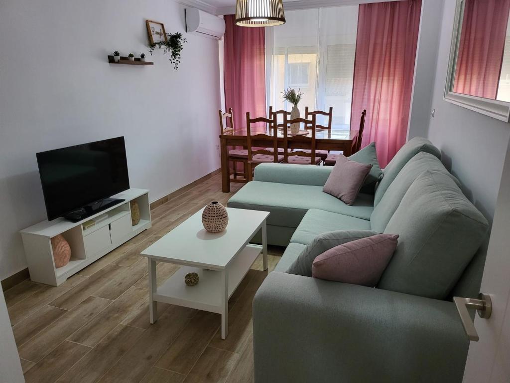 uma sala de estar com um sofá, uma televisão e uma mesa em APARTAMENTO SH em Málaga