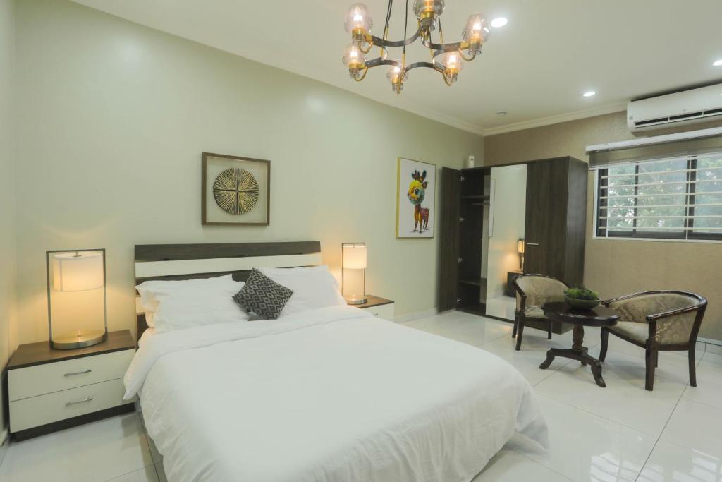 een slaapkamer met een groot wit bed en een bureau bij Accra Luxury Apartments @ Silicon Square in Accra
