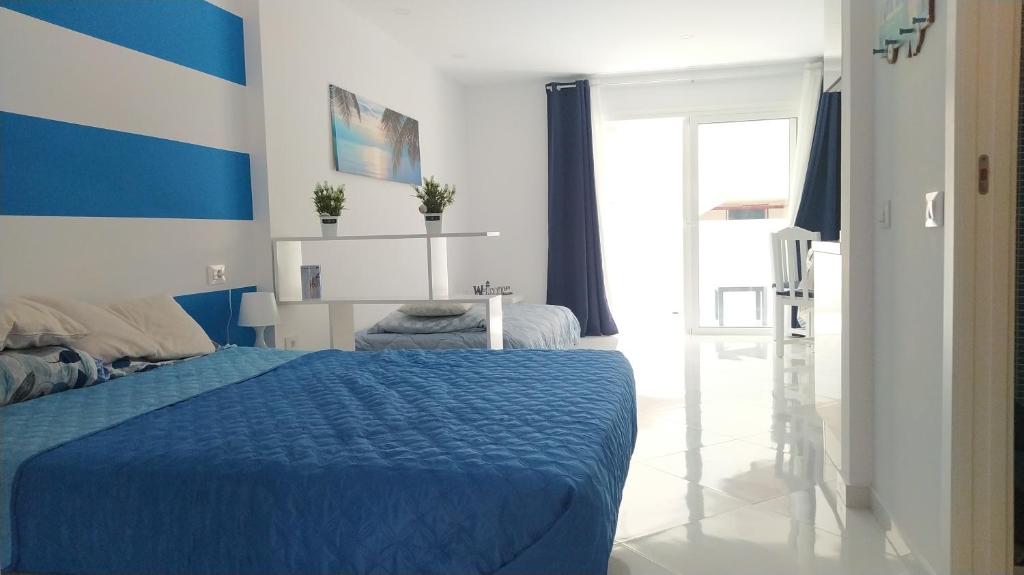 um quarto azul e branco com uma cama azul em Parque Cattleya Las Americas Wifi Pool em Playa de las Americas