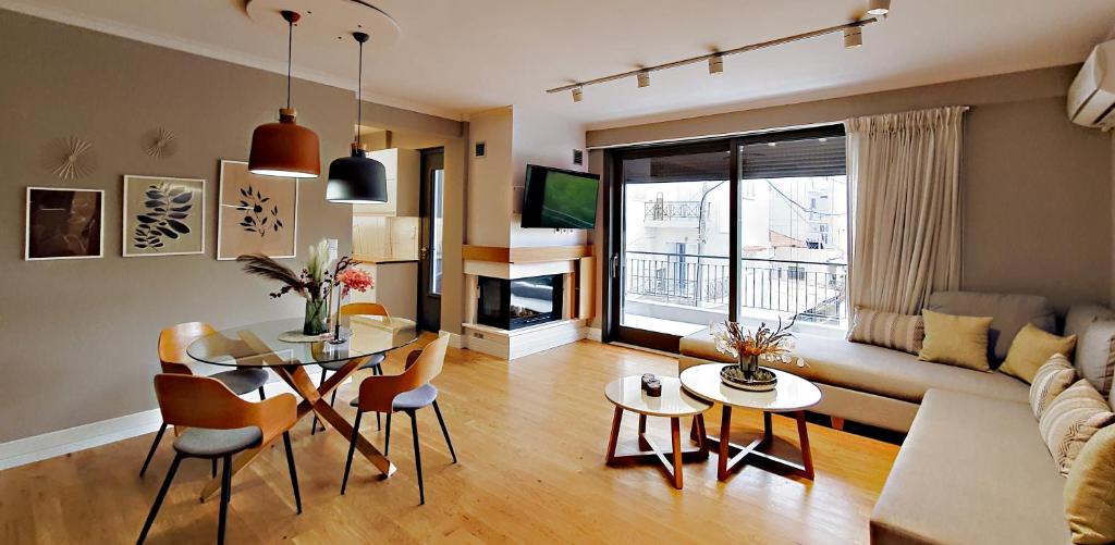 salon ze stołem, krzesłami i kanapą w obiekcie Malamas Apartment w Kalamácie