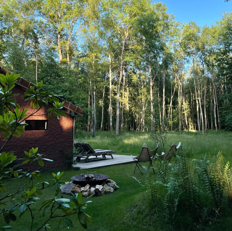 a backyard with a picnic table and a fire pit at CASAMAAS in Les Basses Masures