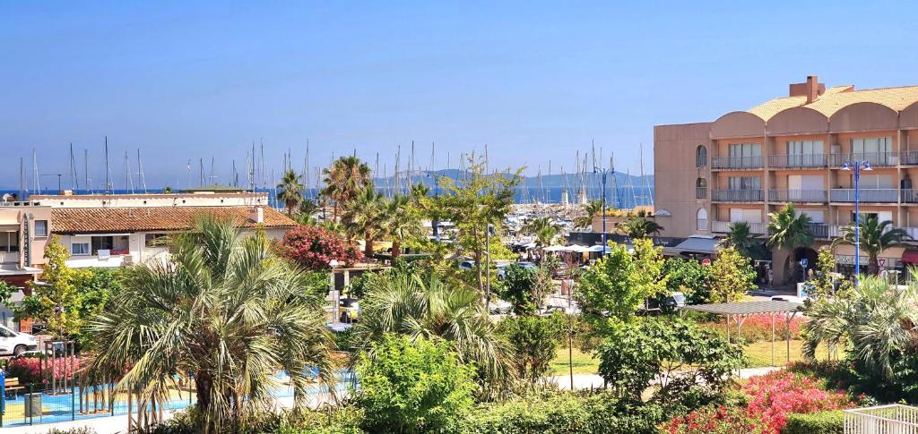 - une vue sur une ville avec des palmiers et un bâtiment dans l'établissement Jolie Vue - La Loge, à Hyères