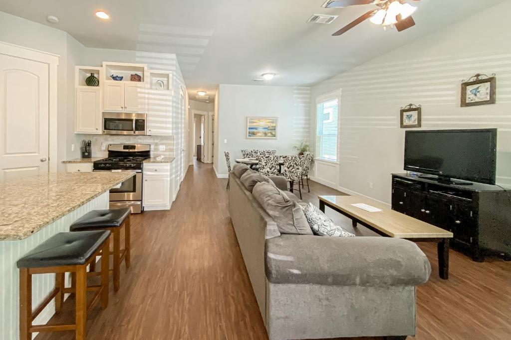 a living room with a couch and a tv and a kitchen at Sunset Sail in Rockport