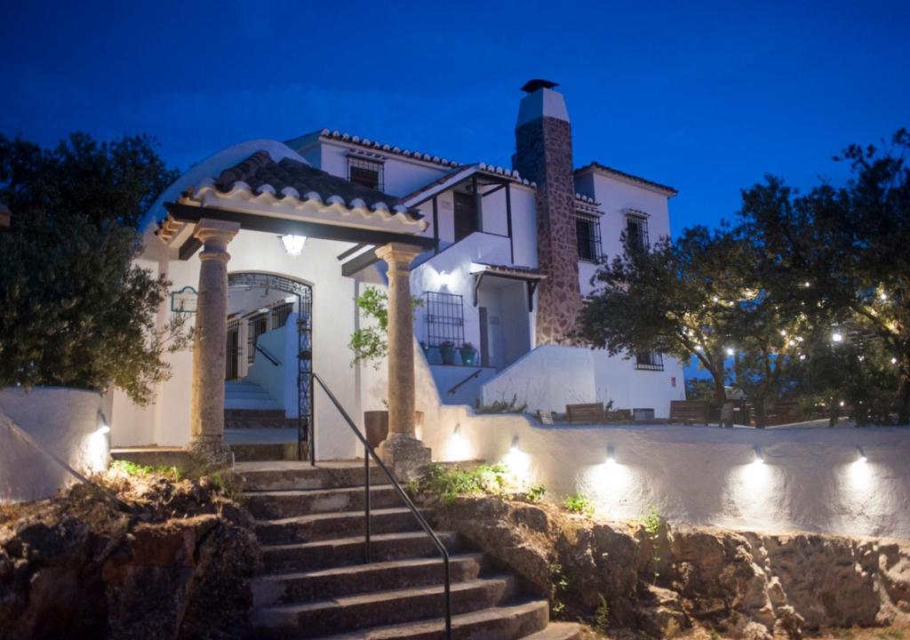 a white house with stairs and lights at night at El Balcón del Rey in Ruidera