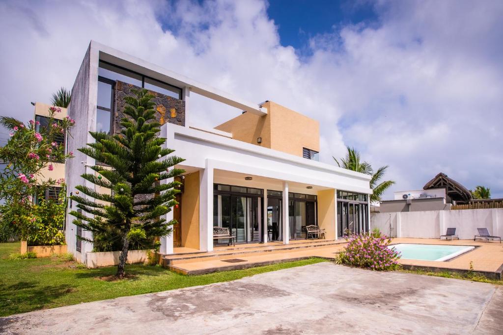 ein Haus mit einem Pool und einem Haus in der Unterkunft Villa Fitz: Sunlit Beach Getaway w/ Pool + WIFI in Belle Mare