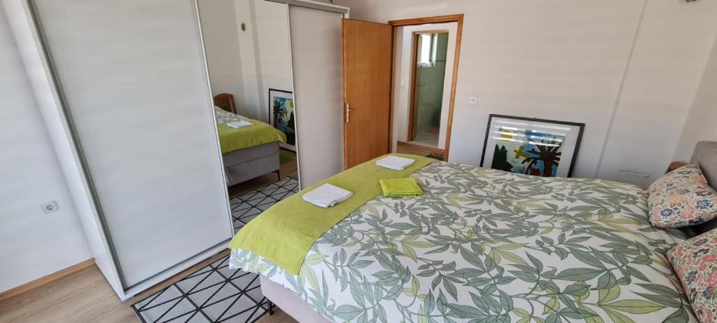 a bedroom with a bed with a green blanket at Urban Home Visoko in Visoko