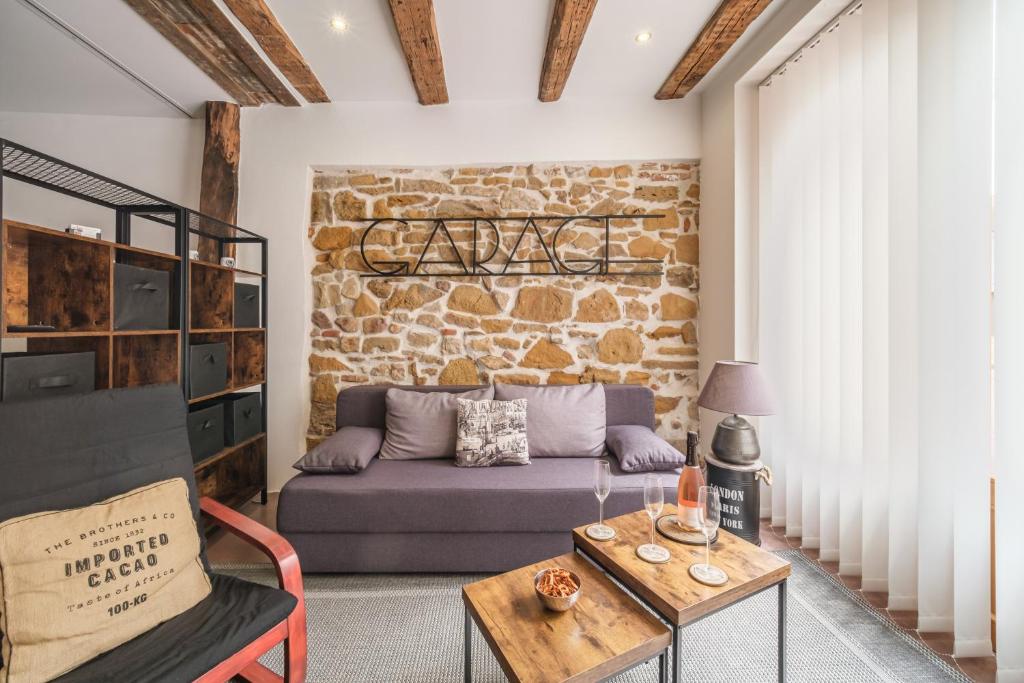 a living room with a couch and a brick wall at La Semeuse Hurst in Colmar