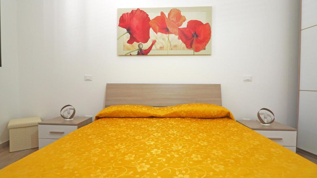 a bedroom with a bed with a yellow bedspread at Casa Manni Taviano-Salento in Taviano