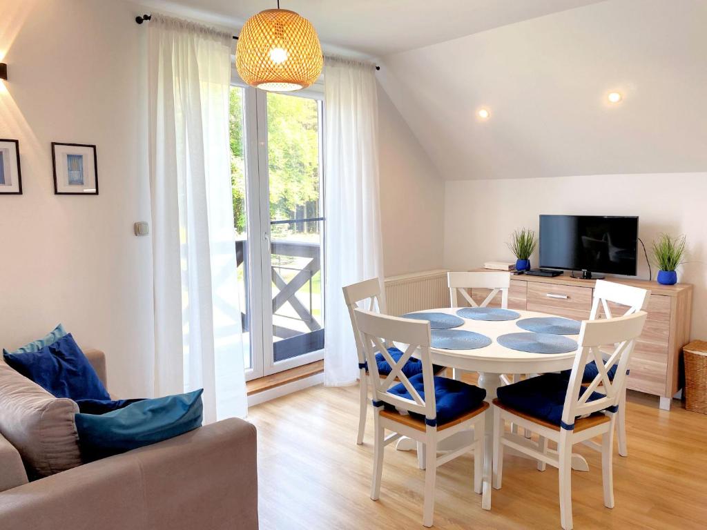 a living room with a table and chairs and a television at Apartament Kalimera in Żarnowska