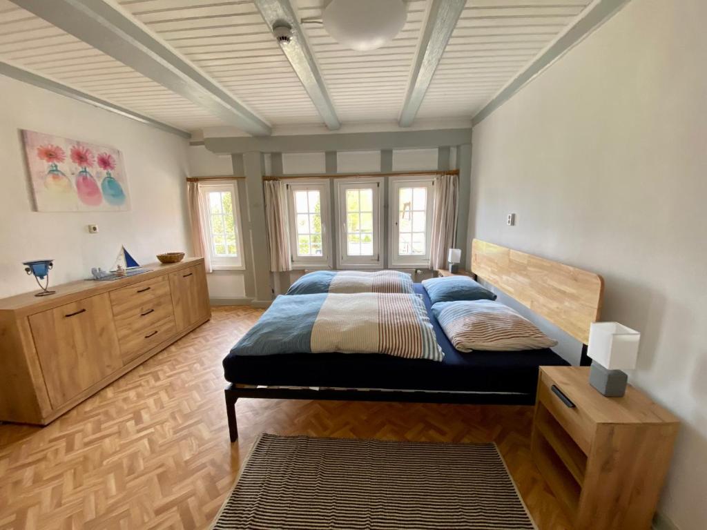 a bedroom with a large bed with a wooden headboard at Großes Ferienhaus an der Ostsee "Oldevighus" in Hohenkirchen