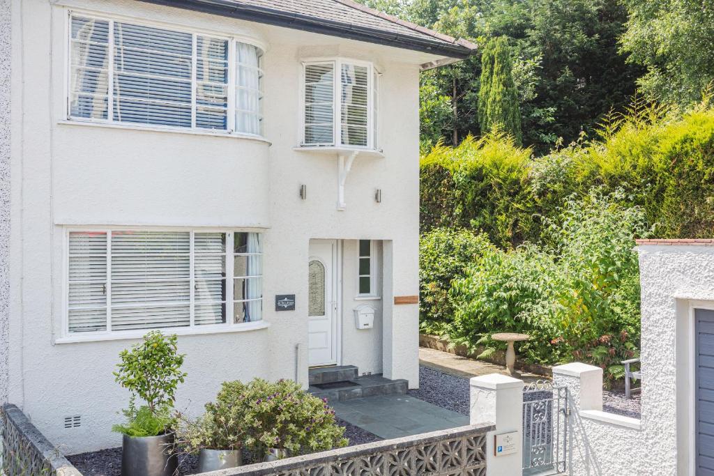 a white house with a gate and a fence at The Art Deco House in Menai Bridge