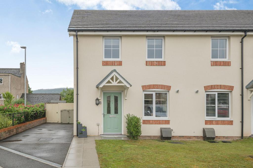 a white house with a green door at Kymin View in Monmouth