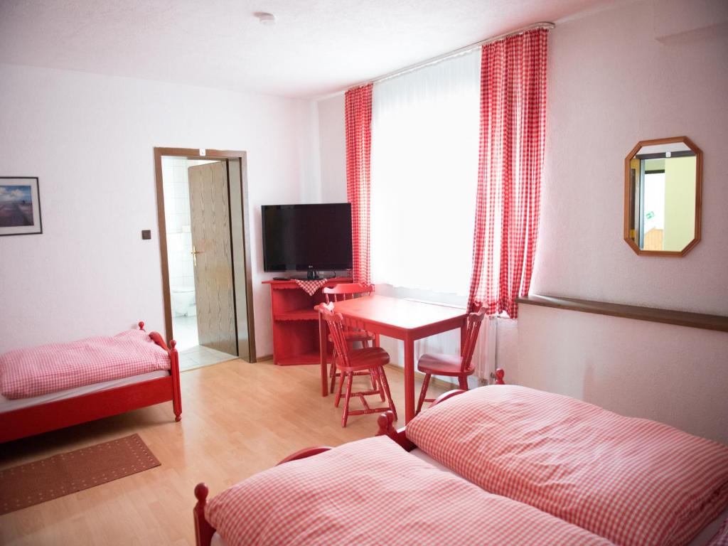 Schlafzimmer mit einem Schreibtisch und einem Tisch mit einem Bett in der Unterkunft Hotel-Restaurant Köhler in Stuttgart
