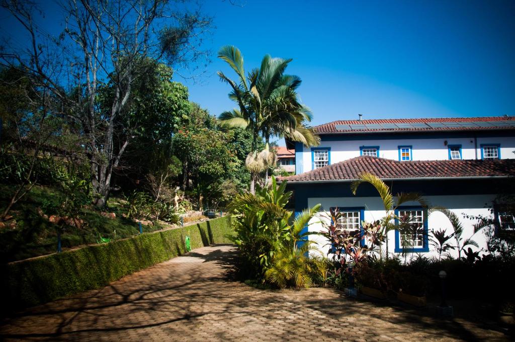 a house with a palm tree in front of it at Pousada Xica da Silva in Tiradentes