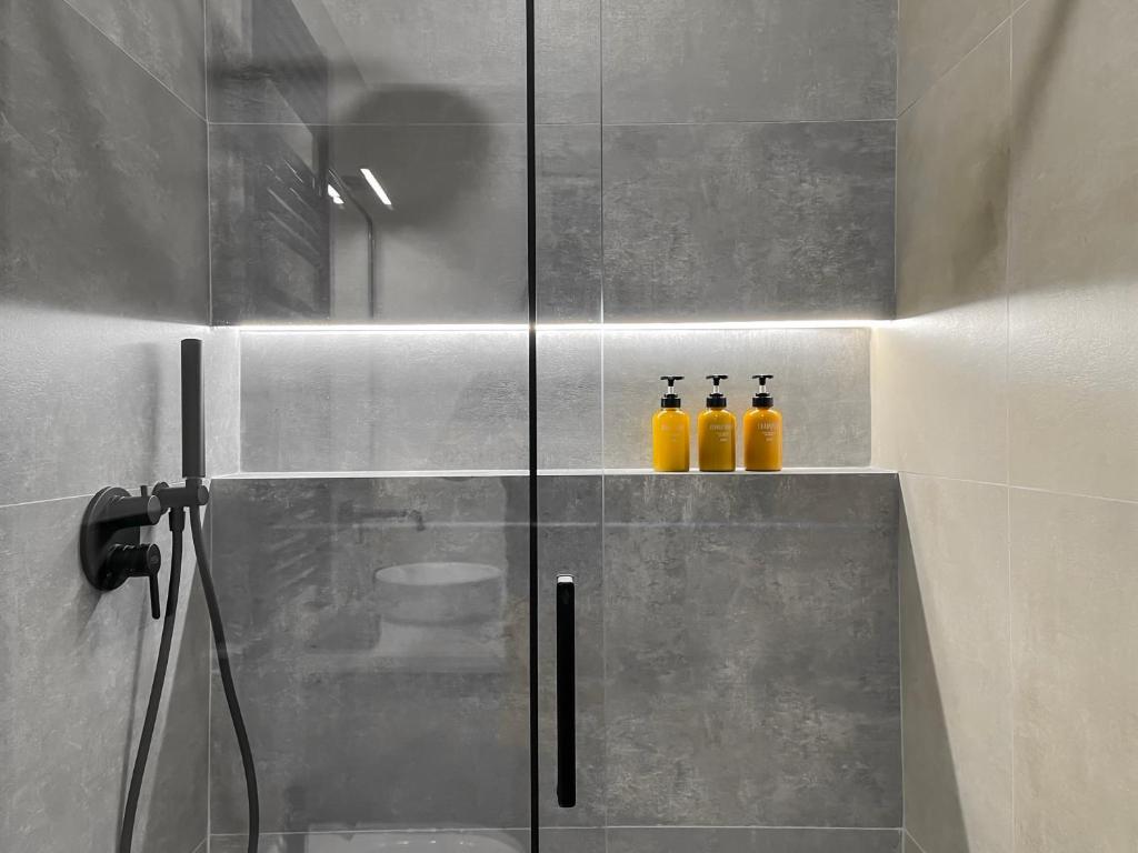 ein Badezimmer mit 3 Flaschen orangefarbener Flüssigkeit in der Unterkunft Appartamento di design in Rom