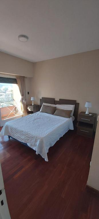 a bedroom with a large bed and a wooden floor at depto salta dean funes in Salta