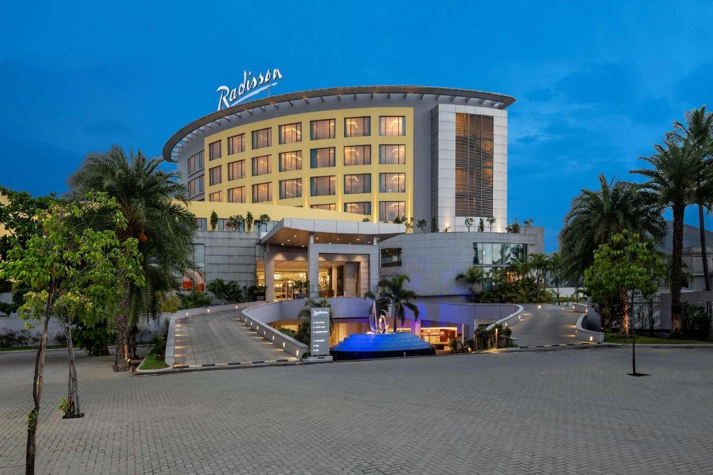 セーラムにあるRadisson Salemのヤシの木が目の前に広がるホテルの建物