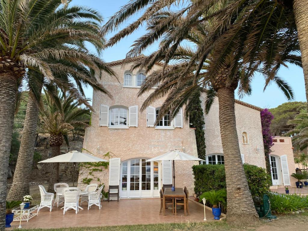 une maison avec des palmiers devant elle dans l'établissement Villa les Palmiers, à Calcatoggio
