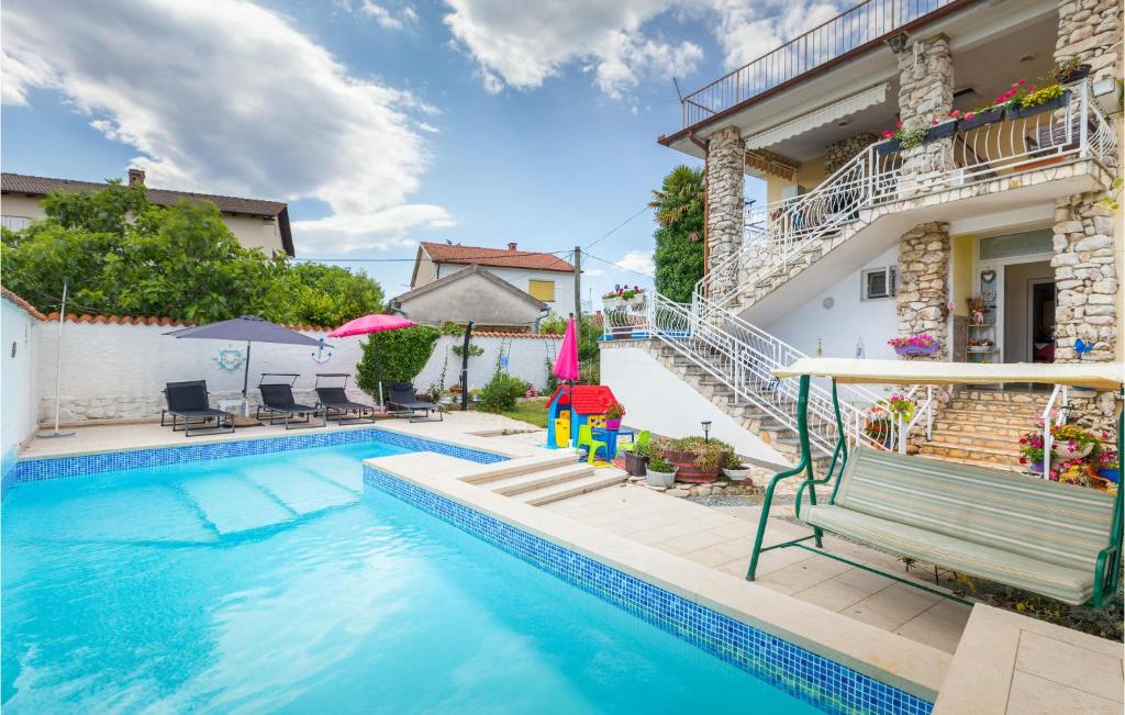 - une piscine avec un banc à côté d'une maison dans l'établissement Amazing Apartment In Valbandon With Outdoor Swimming Pool, à Valbandon