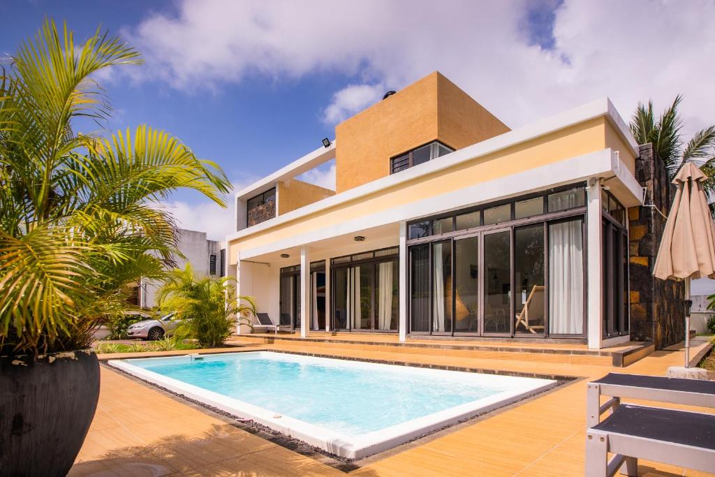 vista esterna di una casa con piscina di Villa Simone: Sunlit Beach Getaway w/ Pool + WIFI a Belle Mare