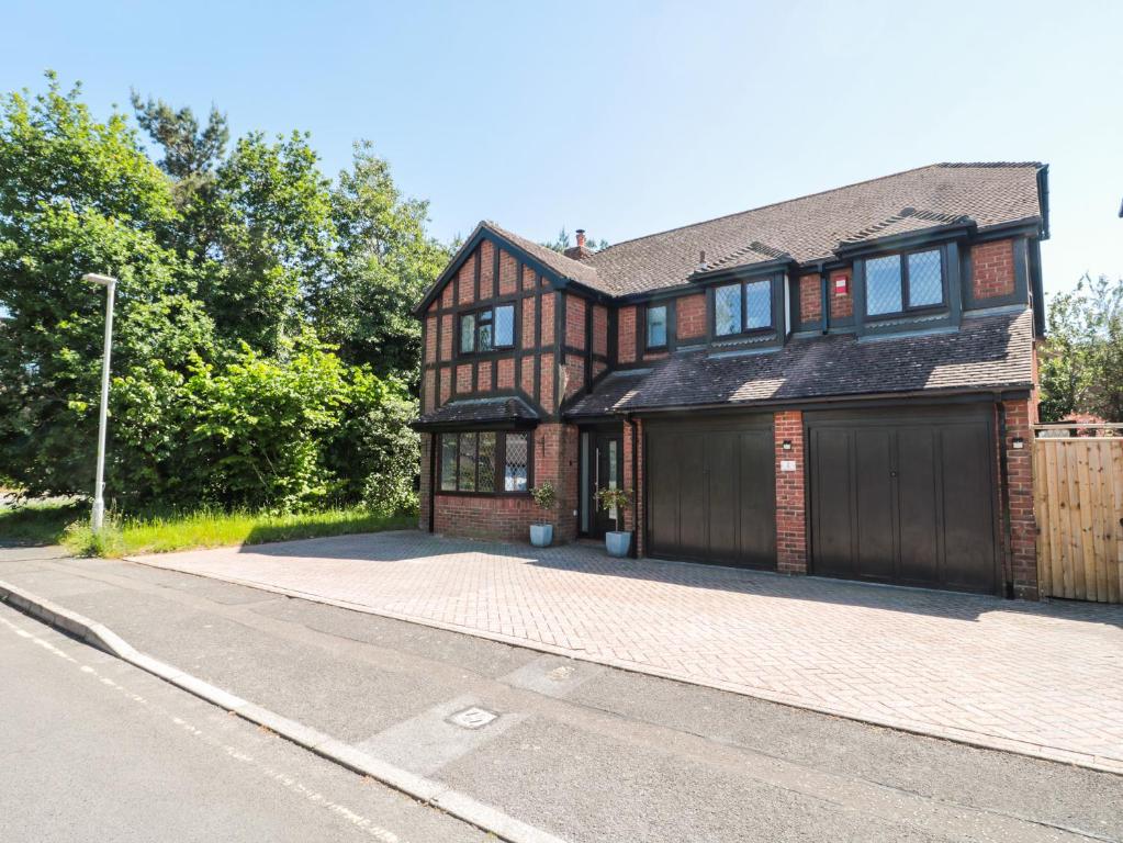 a large brick house with a garage on a street at 1 Charlotte Close in Bournemouth