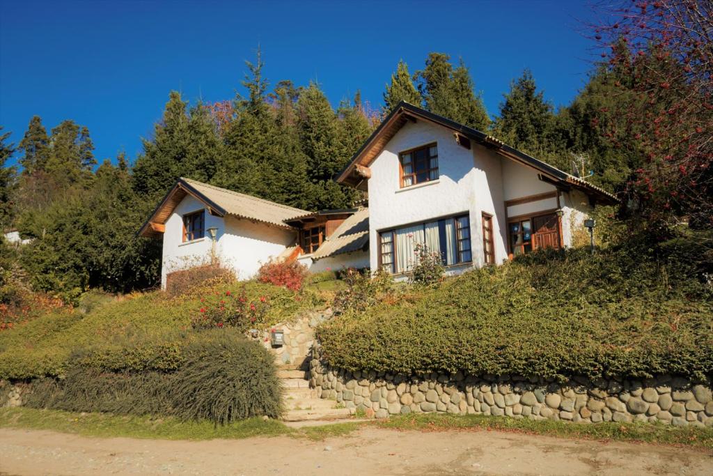 una casa en una colina con una pared de piedra en Mi sueño en San Carlos de Bariloche