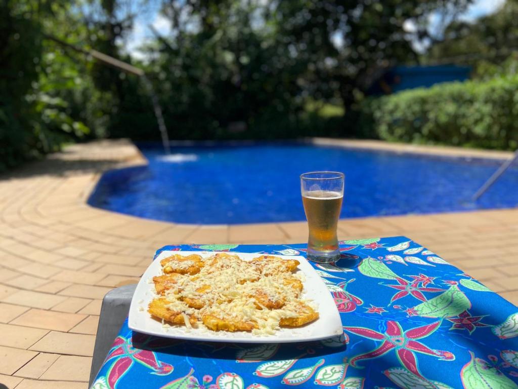 una mesa con un plato de comida y un vaso de cerveza en Hotel El Abrazo del Arbol, en Mindo