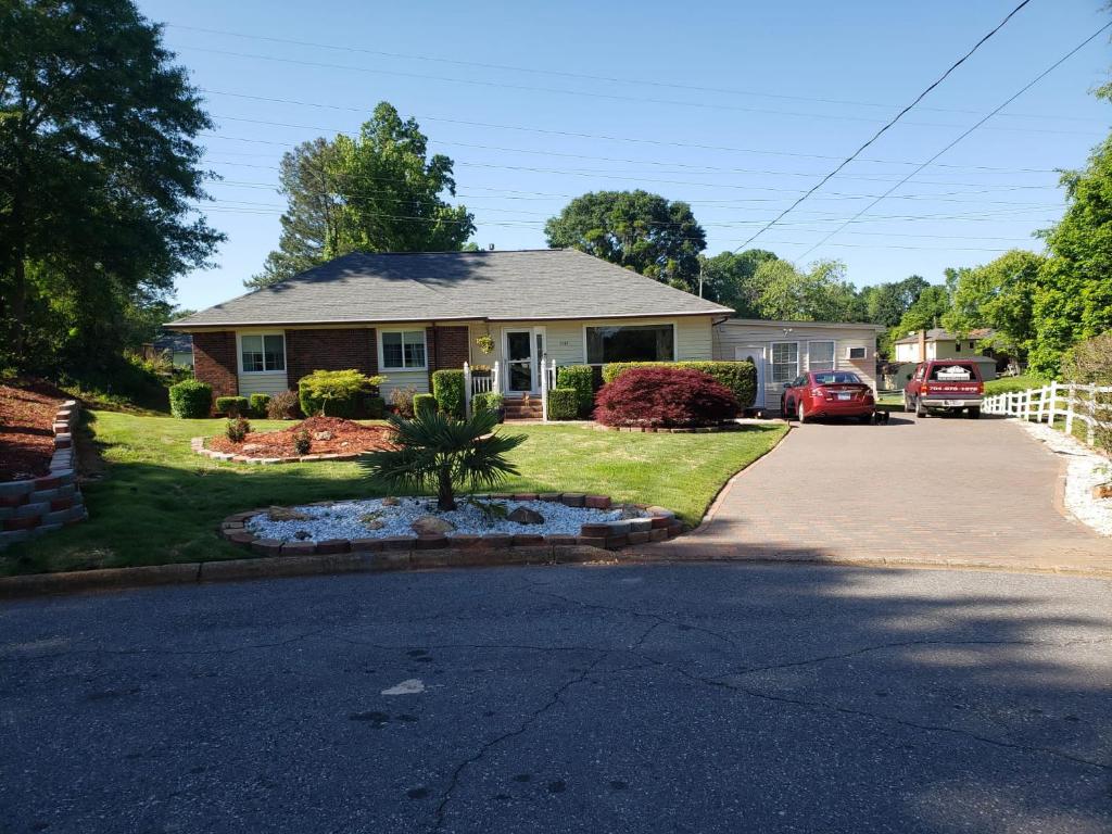 una casa con un árbol en medio de una entrada en Bright & Spacious Studio Close to CLT Airport en Gastonia