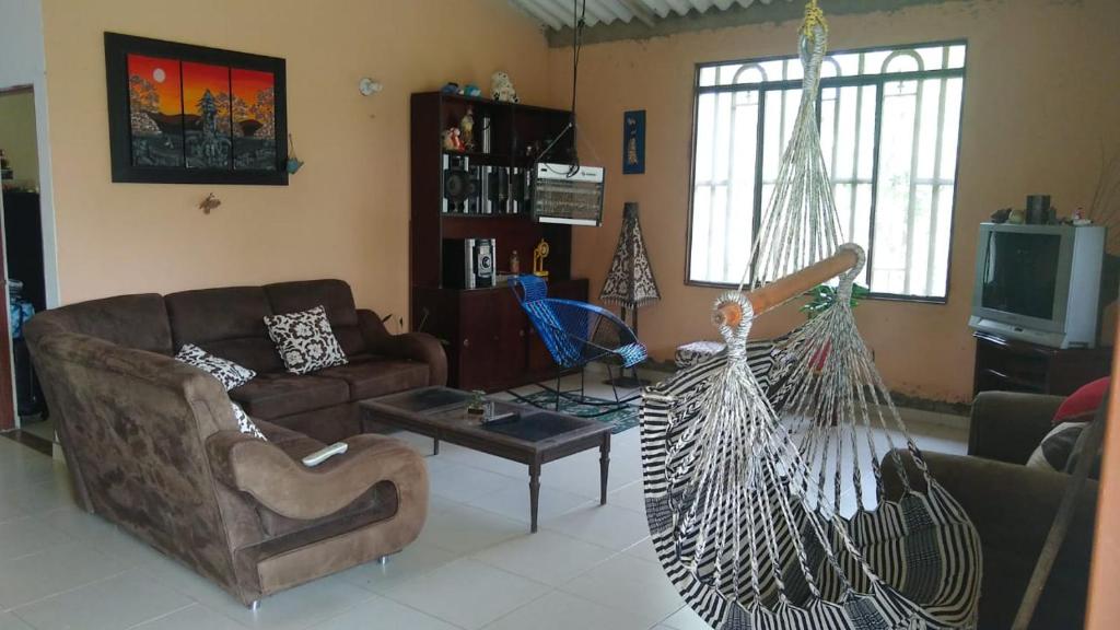 a living room with a couch and a hammock at Casa de descanso - Finca Los Primos in San Luis de Cubarral