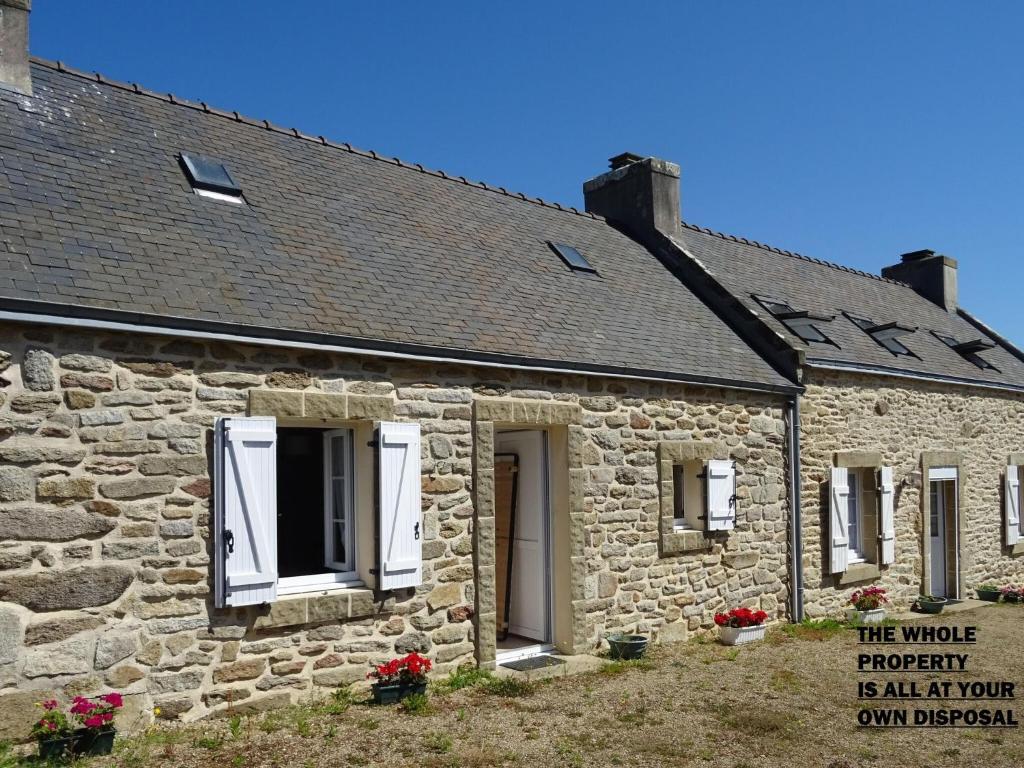 Cette ancienne maison en pierre est dotée d'une fenêtre blanche. dans l'établissement Stone House in Treboul near Pointe du Raz, à Douarnenez