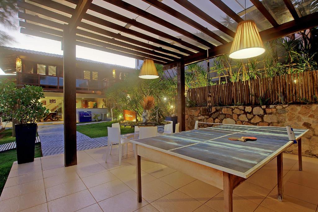 une terrasse avec une table de ping-pong et des lumières dans l'établissement Casa espetacular na Praia de Taíba por Carpediem, à São Gonçalo do Amarante