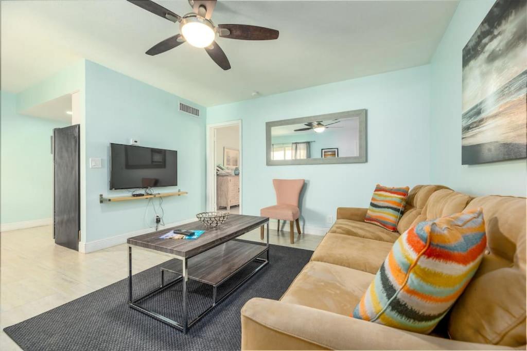 ein Wohnzimmer mit einem Sofa und einem TV in der Unterkunft Steps to Sand and Sea 2 in Fort Lauderdale