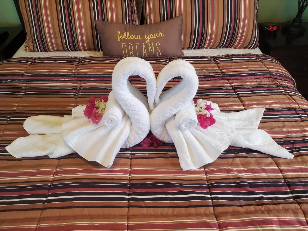 two swans are made to look like hearts on a bed at Annasville Comfort Studio in St Thomas