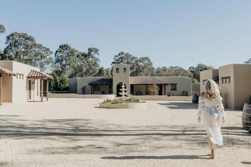 a woman walking in front of a building at Casa La Vina Villas Pokolbin in Pokolbin