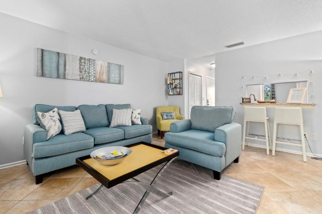 ein Wohnzimmer mit 2 blauen Sofas und einem Tisch in der Unterkunft Shell house retreat in Sarasota