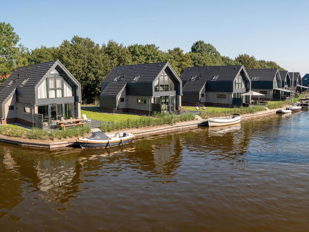 una fila de casas en el agua con barcos en Luxurious detached water villa with jetty, en Balk