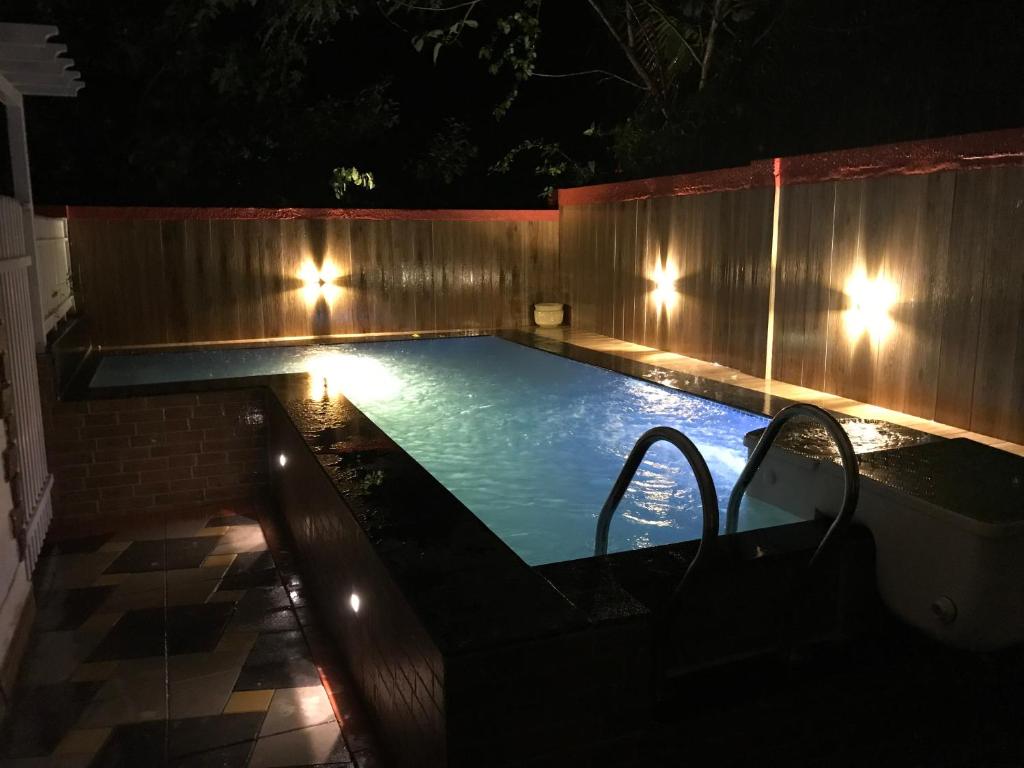 ein Schwimmbad mit Lichtern in einem Hinterhof in der Nacht in der Unterkunft 3 Bedroom villa with Private Pool in North Goa in Assagao