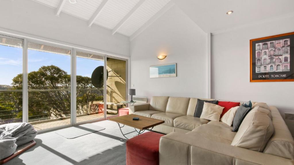 a living room with a couch and a large window at Razorback 6 in Mount Hotham
