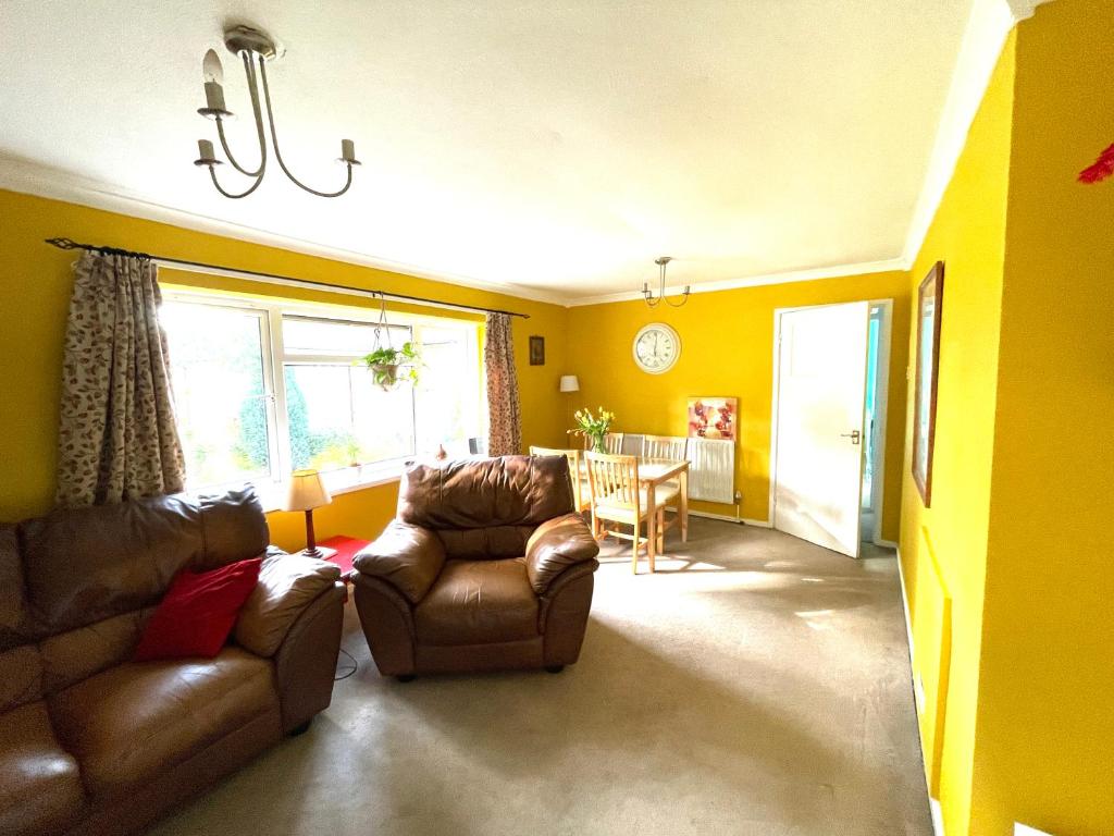 a living room with a couch and chairs and a table at Spacious 2 bed flat. in Whittington