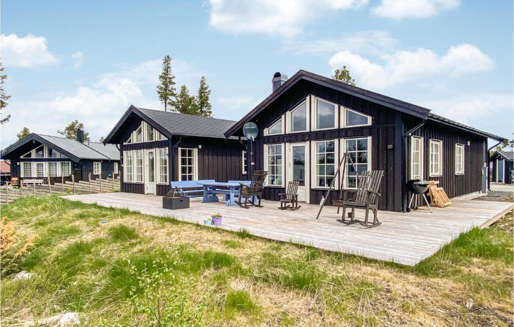 Golsfjelletにある4 Bedroom Nice Home In Tisleidalenの木製デッキが目の前にある大きな黒い家