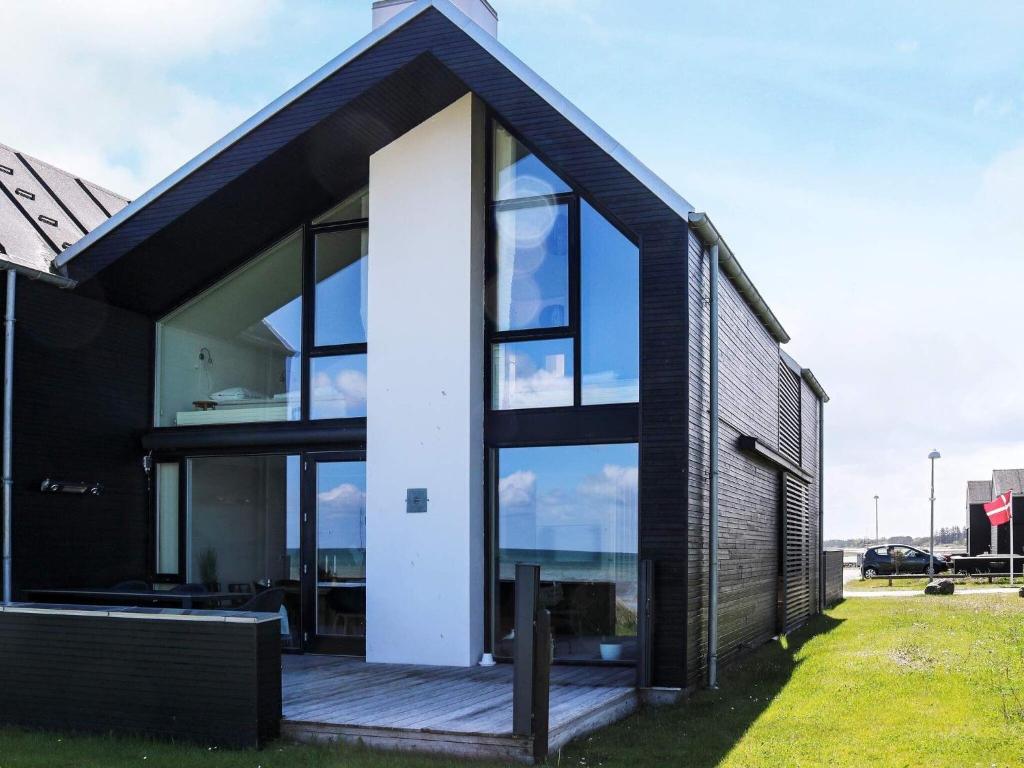 uma casa a preto e branco com grandes janelas de vidro em Holiday home Hadsund CXXXI em Hadsund