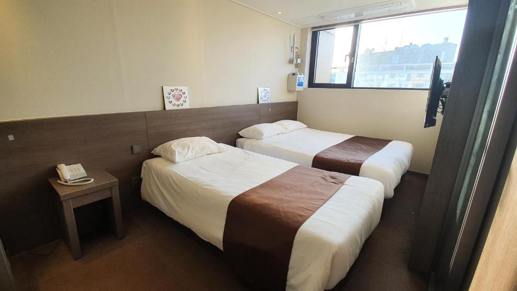 Postel nebo postele na pokoji v ubytování Grandmillions Hotel Seogwipo