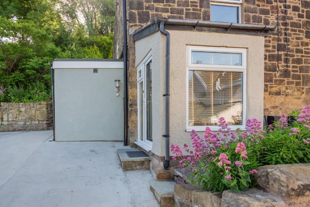 een deur aan de zijkant van een bakstenen gebouw met bloemen bij 27 Green Road in Wrexham