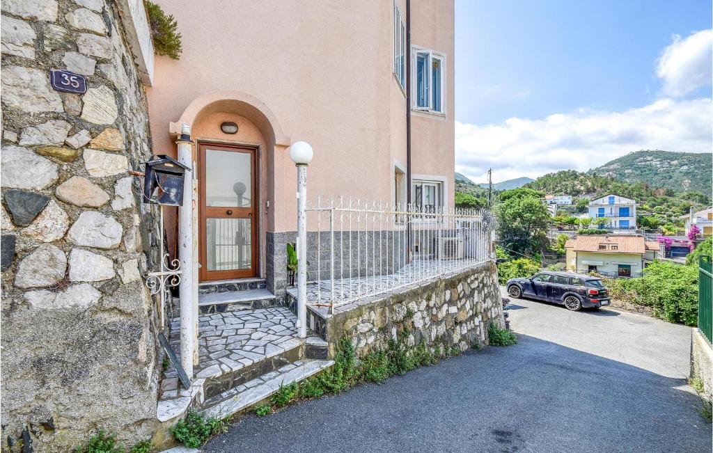 a building with a fence next to a house at Amazing Home In Spotorno With Wifi in Spotorno