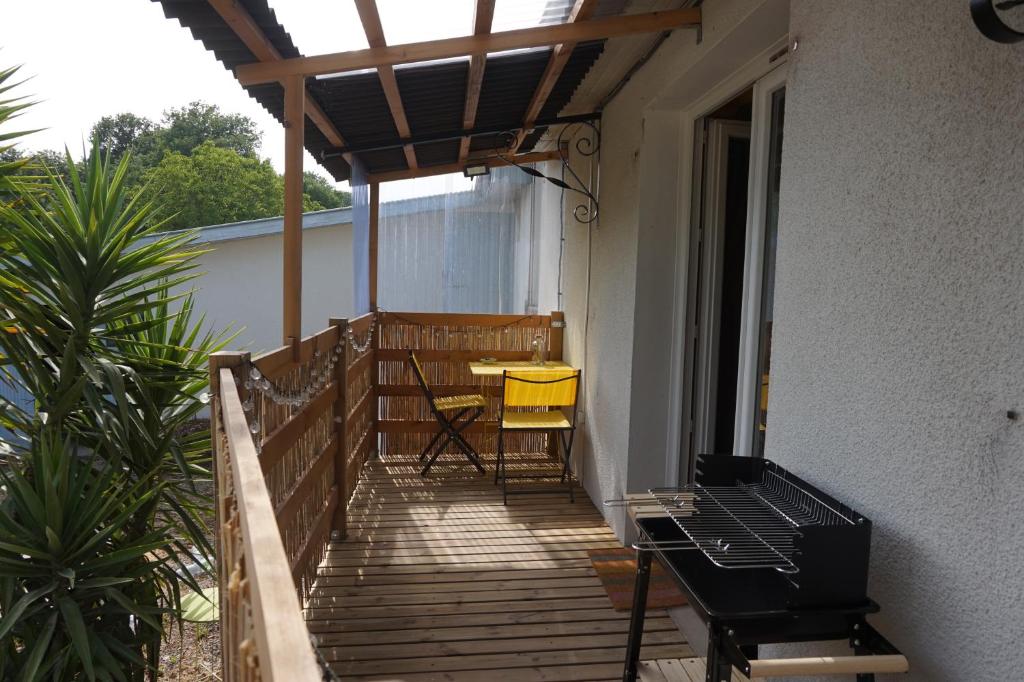 un balcón con mesa y sillas en el porche en Maison champêtre et joyeuse à la campagne en Berenx