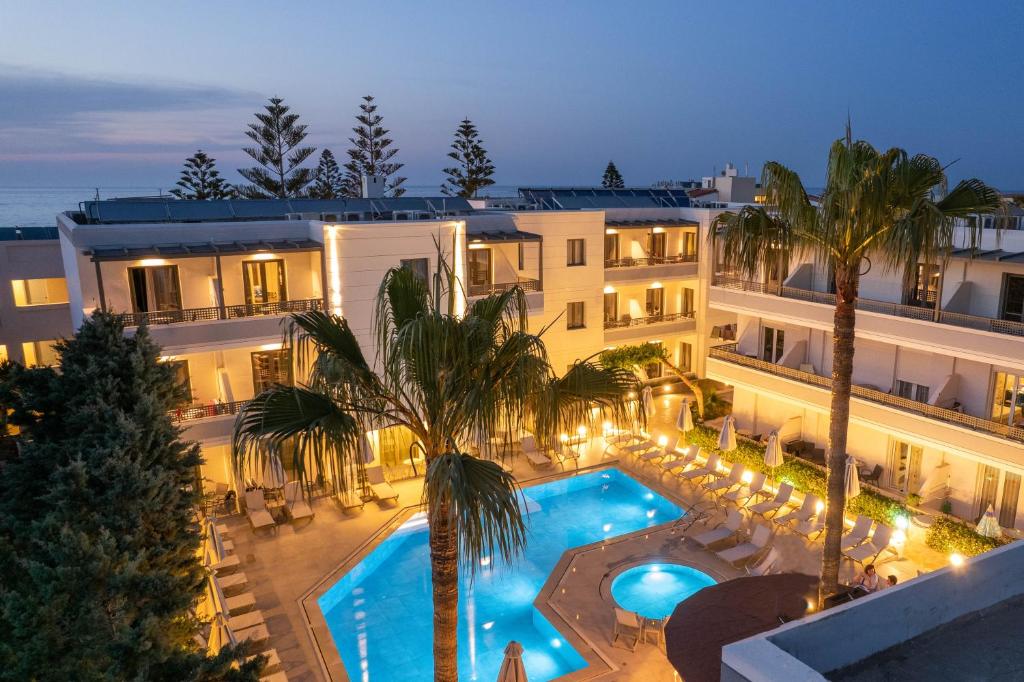 ein Hotel mit einem Pool vor einem Gebäude in der Unterkunft Summer Dream in Rethymno